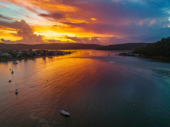 Aerial sunrise waterscape with boats, colour and clouds