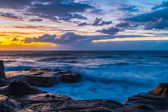 Sunrise, sea, waves, clouds and tessellated rock platform