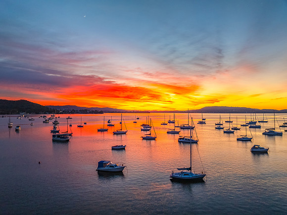 Aerial sunrise waterscape with boats and high cloud