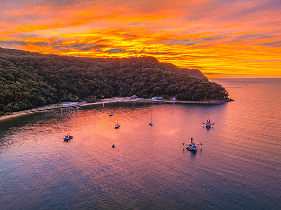 Sunrise over the bay with boats and cloud covered sky
