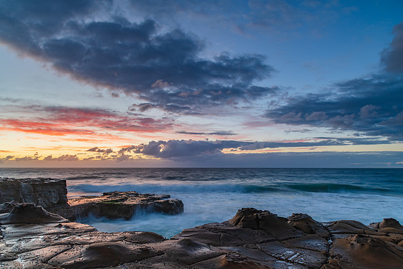 Sunrise, sea, waves, clouds and tessellated rock platform