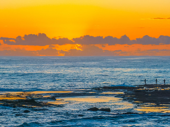 Sunrise over the sea and rocks with clear skies