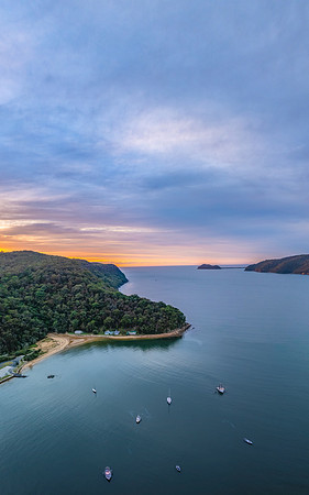 Sunrise over the bay with boats and cloud covered sky