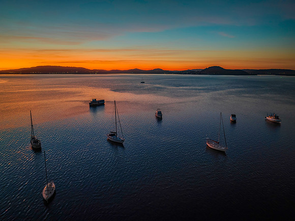 Aerial sunrise waterscape with boats and high cloud