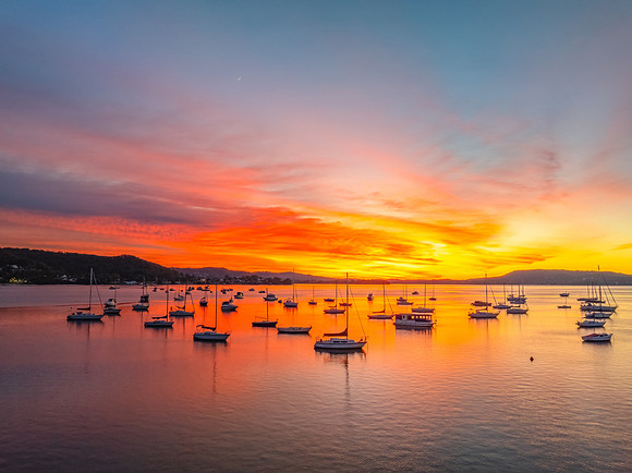 Aerial sunrise waterscape with boats and high cloud