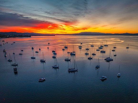 Aerial sunrise waterscape with boats and high cloud
