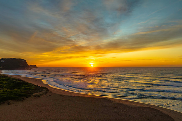 Sunrise and high cloud cover by the sea and lagoon