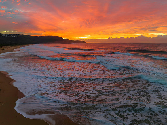 Cloud covered sunrise at the seaside in pink and blue