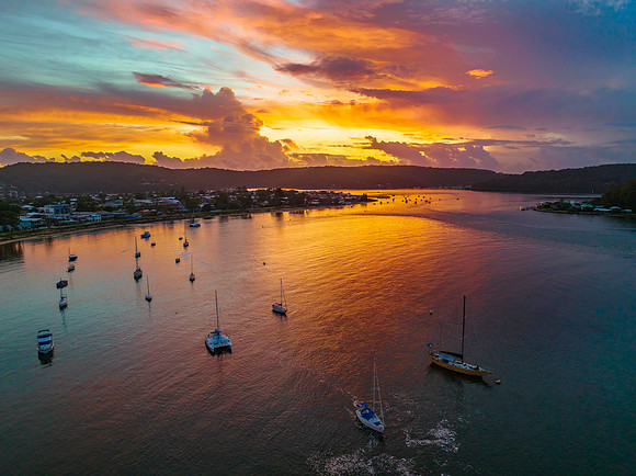 Aerial sunrise waterscape with boats, colour and clouds