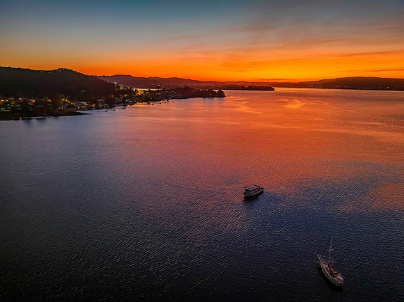 Aerial sunrise waterscape with boats and high cloud