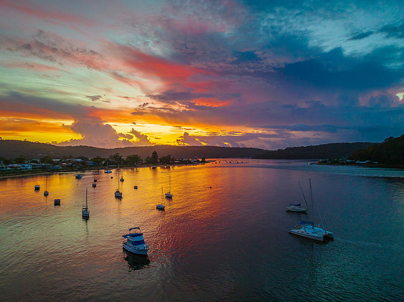 Aerial sunrise waterscape with boats, colour and clouds