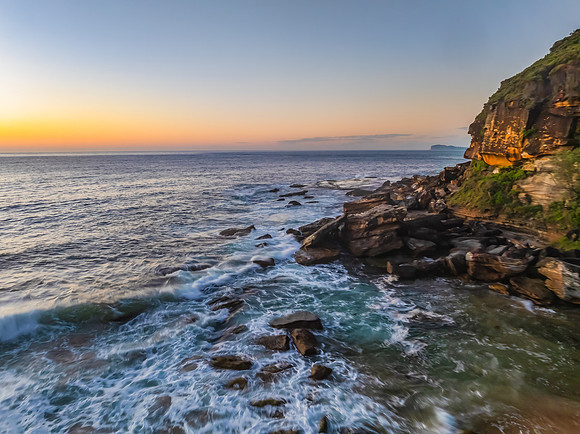 Sunrise seascape with clear skies and orange horizon