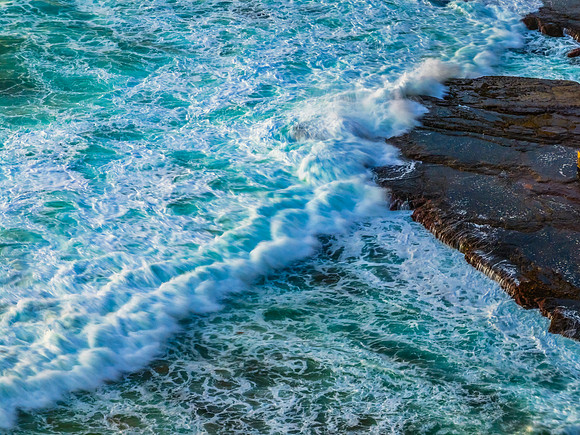 Sunrise at the beach with waves and a smattering of clouds