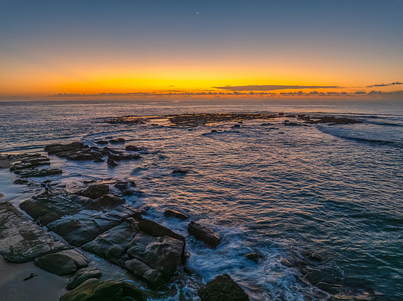 Sunrise over the sea and rocks with clear skies