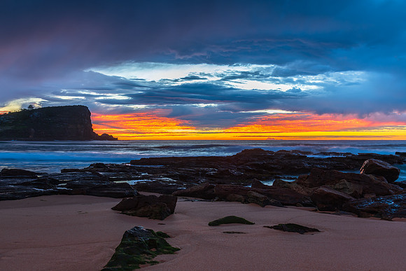 Winter sunrise by the sea shore with rain clouds