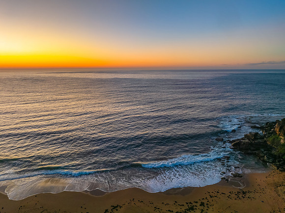 Sunrise seascape with clear skies and orange horizon