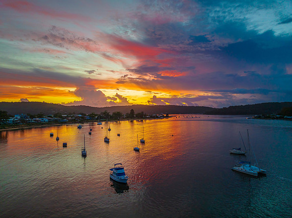 Aerial sunrise waterscape with boats, colour and clouds