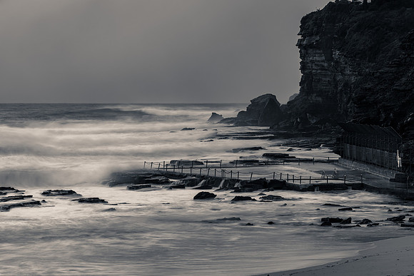 Moody monochrome sunrise with waves at the seaside