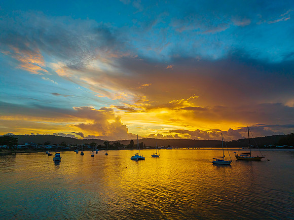 Aerial sunrise waterscape with boats, colour and clouds