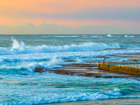 Sunrise at the beach with waves and a smattering of clouds