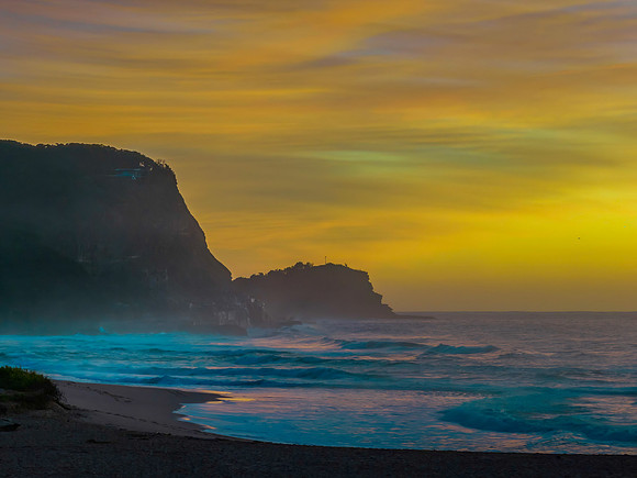 Sunrise and high cloud cover by the sea and headland