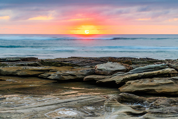 Sunrise seascape with rocky foreground