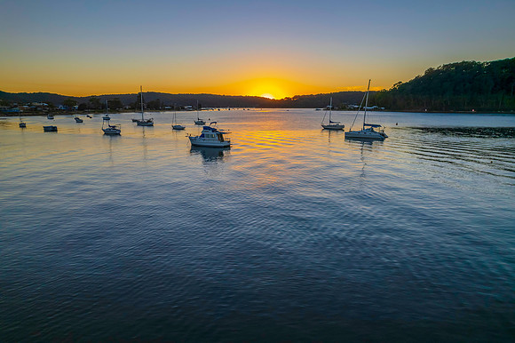 Aerial sunrise waterscape with boats and clear skies