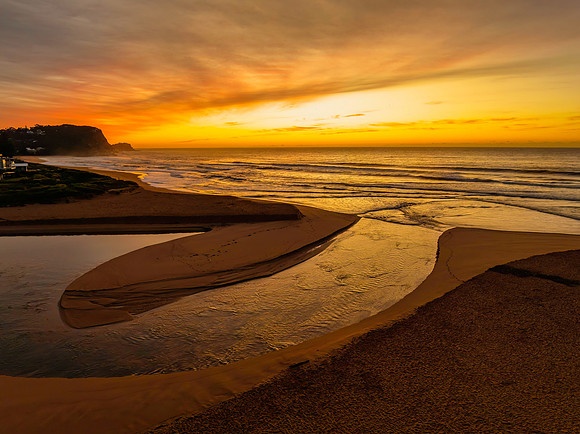 Sunrise and high cloud cover by the sea and lagoon