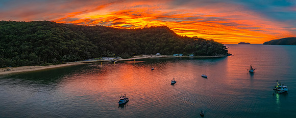 Sunrise over the bay with boats and cloud covered sky