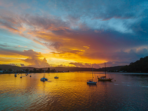 Aerial sunrise waterscape with boats, colour and clouds