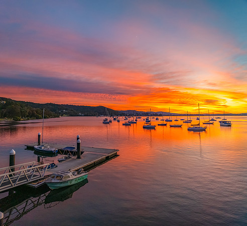 Aerial sunrise waterscape with boats and high cloud