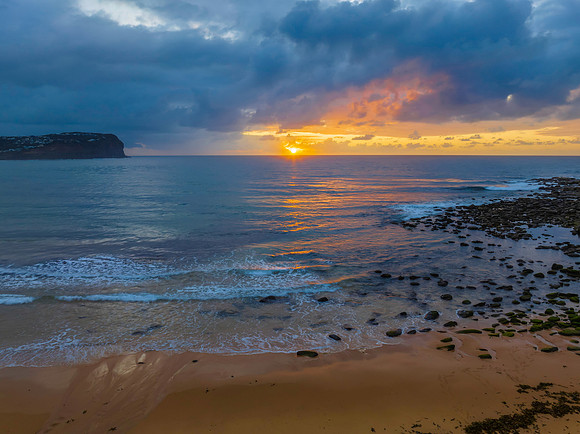 Drizzly moody sunrise seascape with cloud filled sky