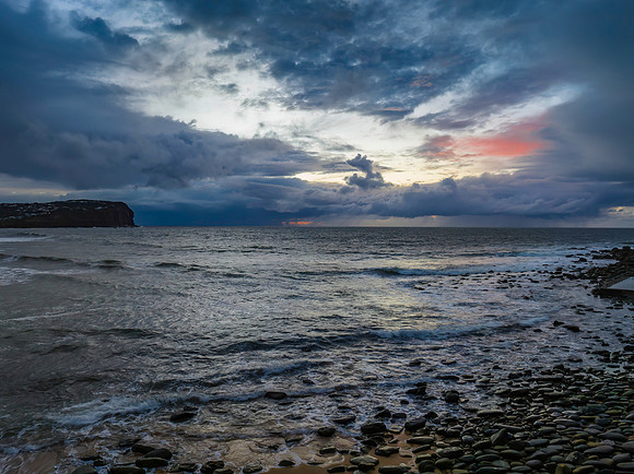 Moody sunrise seascape with rain clouds