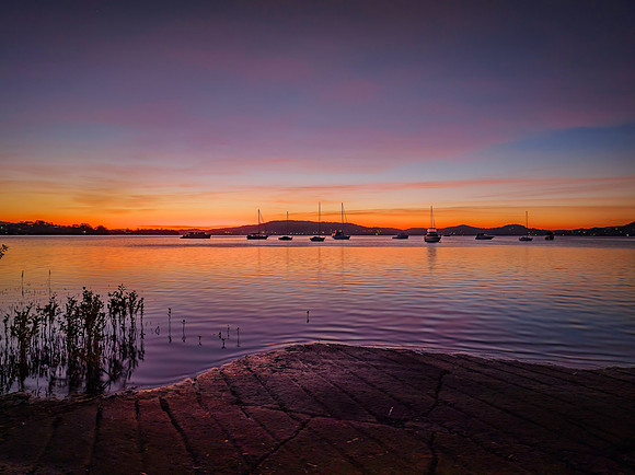 Aerial sunrise waterscape with boats and high cloud