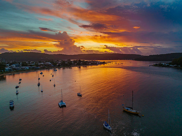 Aerial sunrise waterscape with boats, colour and clouds