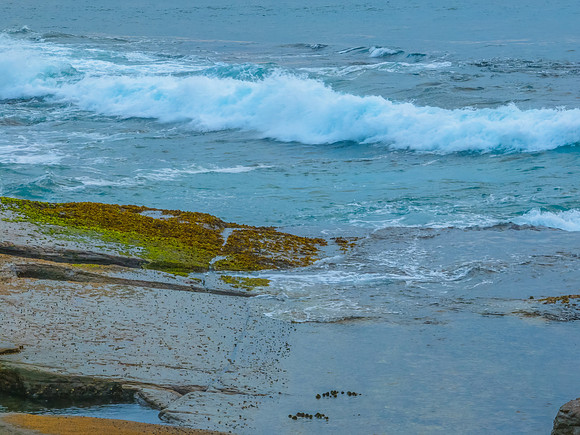 Sunrise seascape and rocky Inlet with thick fog cloud over the o