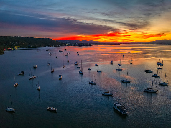 Aerial sunrise waterscape with boats and high cloud