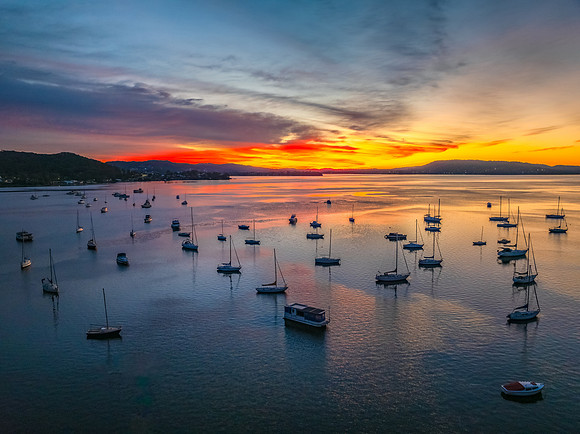 Aerial sunrise waterscape with boats and high cloud