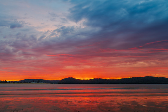 Colourful cloud filled sunrise at the seaside