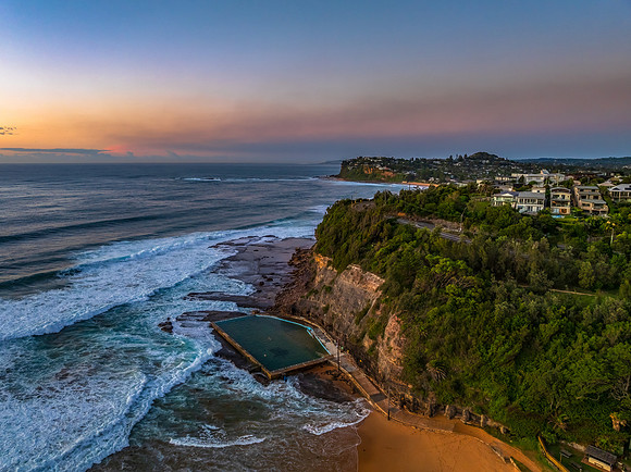 Sunrise at the beach with waves and a smattering of clouds