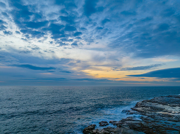 Dreamy soft-hued sunrise seascape over the ocean with high cloud