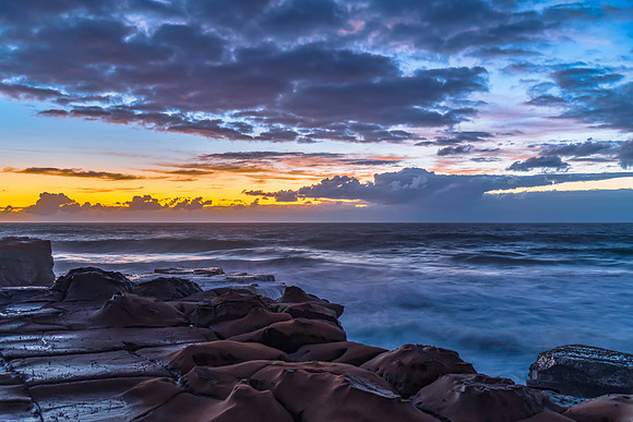 Sunrise, sea, waves, clouds and tessellated rock platform