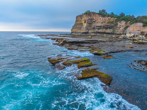 Sunrise seascape and rocky Inlet with thick fog cloud over the o