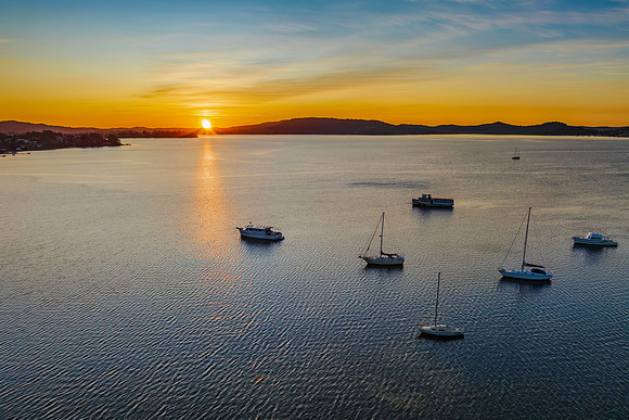 Aerial sunrise waterscape with boats and high cloud