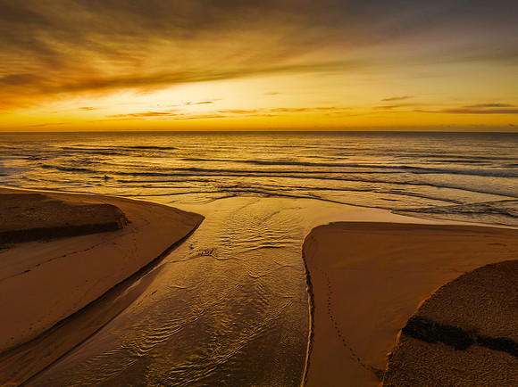 Sunrise and high cloud cover by the sea and lagoon