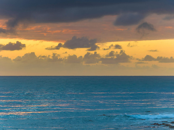 Drizzly moody sunrise seascape with cloud filled sky