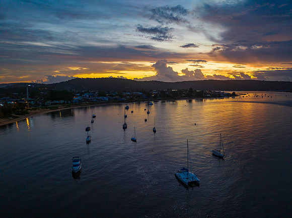 Aerial sunrise waterscape with boats, colour and clouds