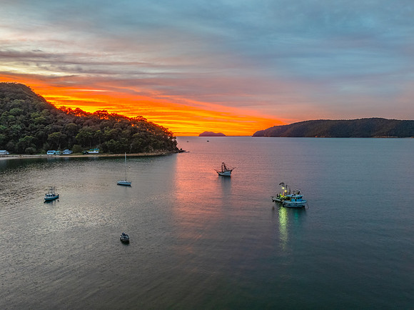 Sunrise over the bay with boats and cloud covered sky